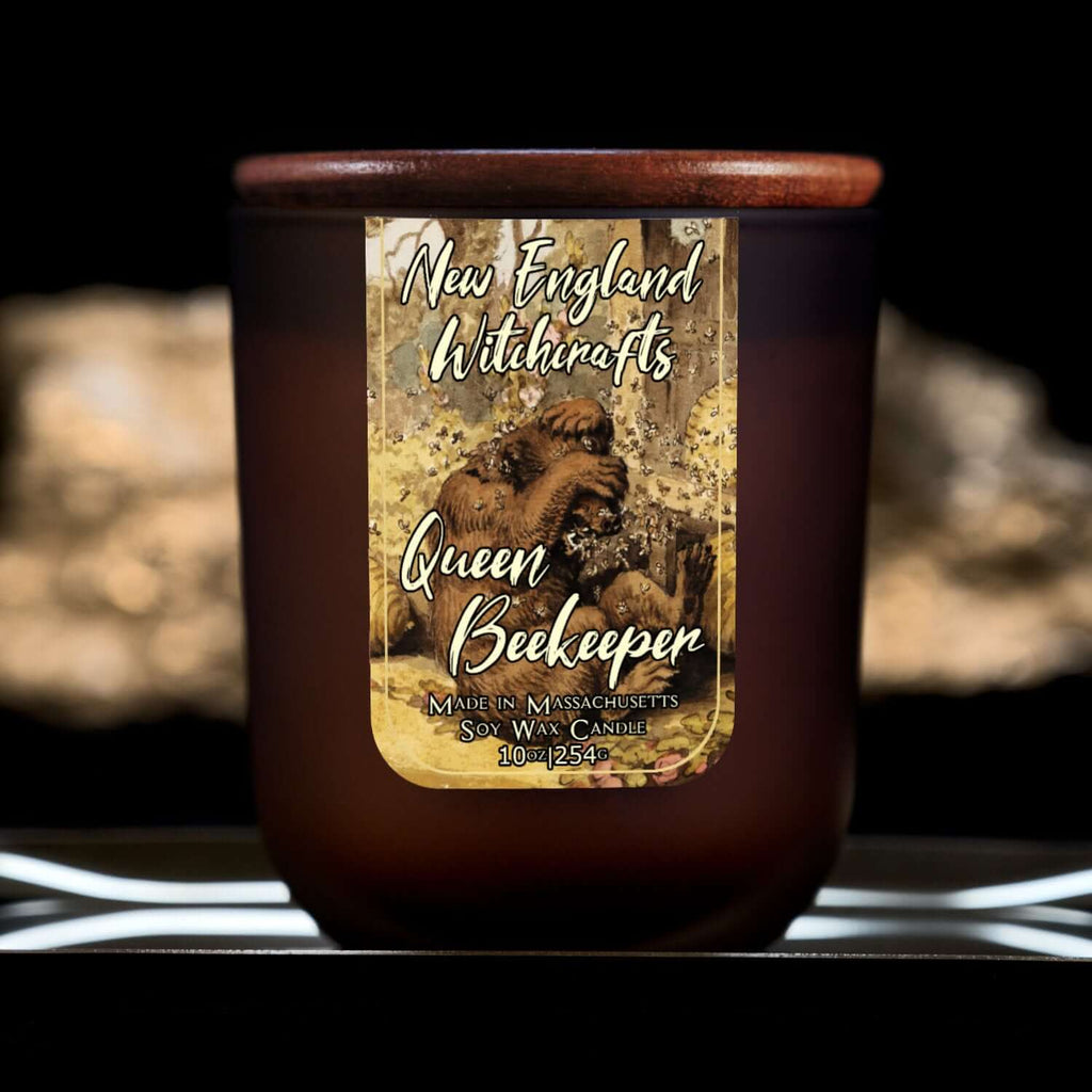 Image depicts a frosted amber candle jar with lid and a label depicting an oil painting of a bear being attacked by bees.