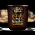 Image depicts a frosted amber candle jar with lid and a label depicting an oil painting of a drunken tavern guest