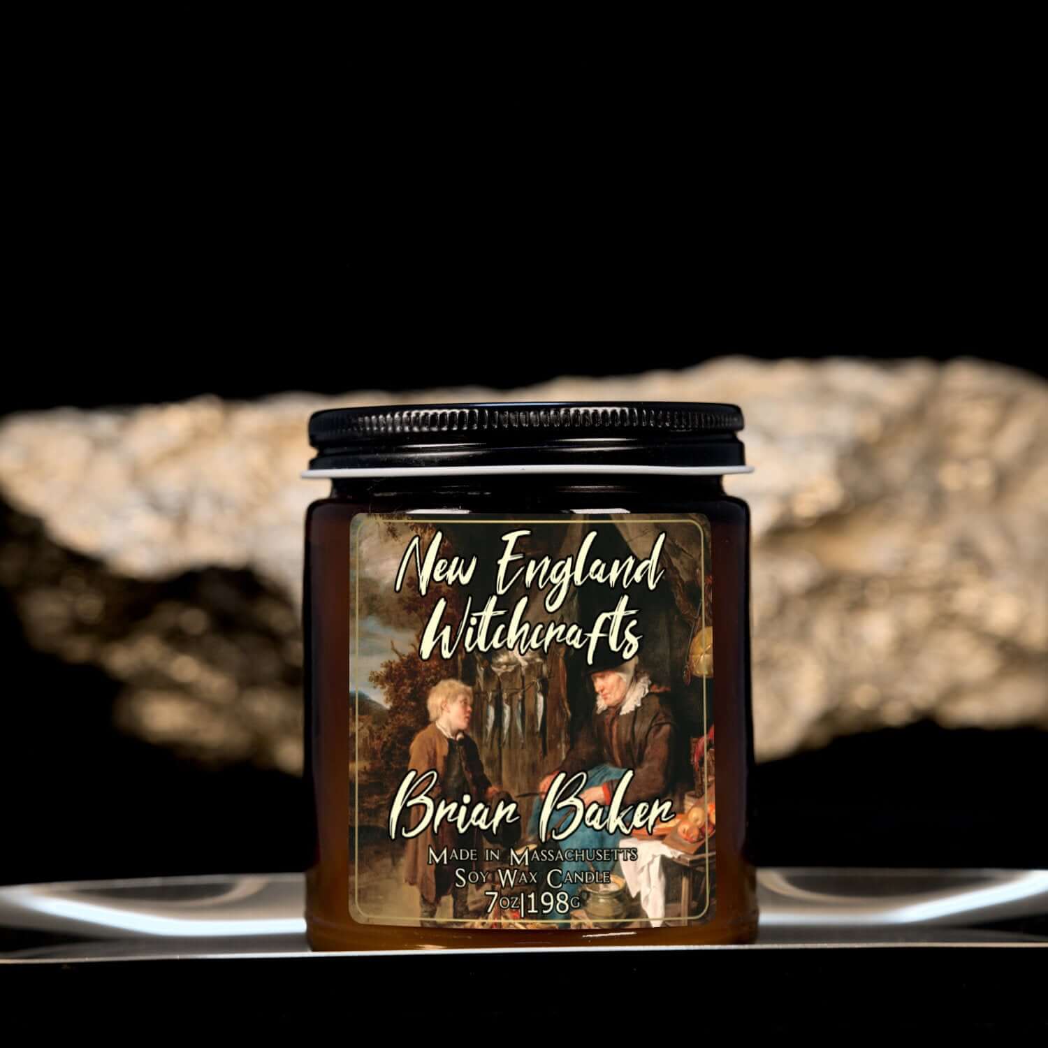 Image depicts an amber candle with black lid, smaller, and a label depicting an oil painting of a child conversing with an old baker woman.